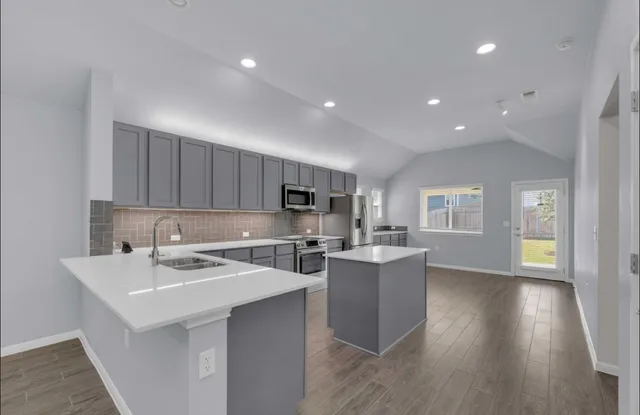 a kitchen with a sink cabinets and wooden floor