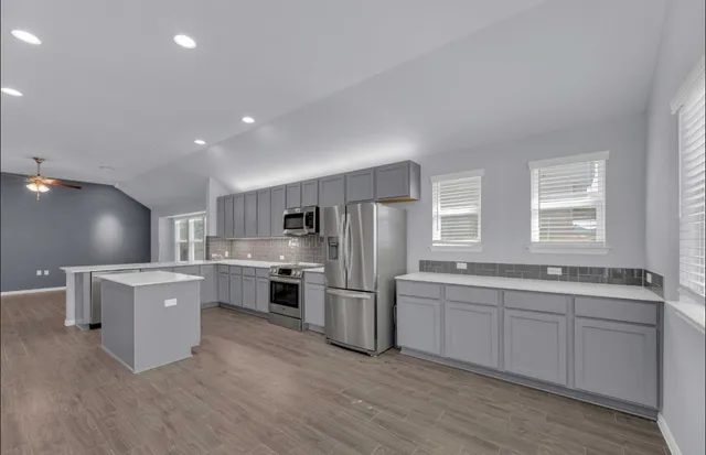 a large kitchen with a center island and stainless steel appliances