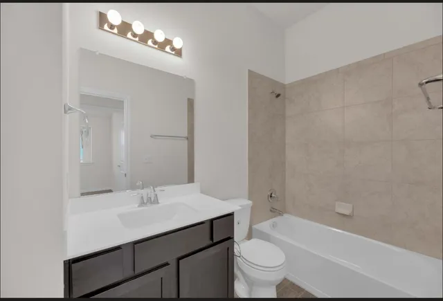 a bathroom with a sink a toilet a mirror a bathtub and shower