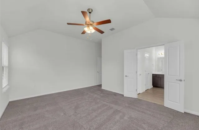 an empty room with closet and windows