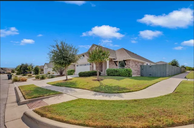 a view of a house with a big yard and potted plants