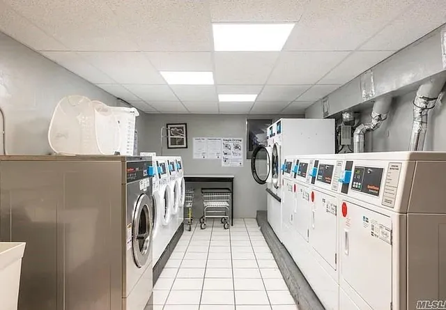 a hallway with white cabinets and washer