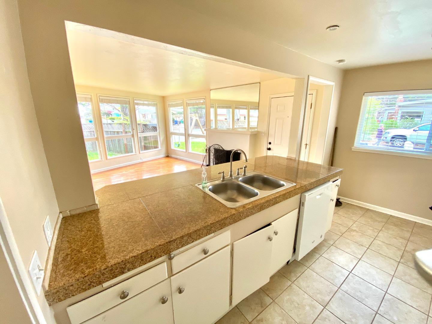 90 Quarterdeck Way Pacific Grove, CA 93950 - Photo 5 of 14 a kitchen with stainless steel appliances granite countertop a sink and a white cabinets next to a window