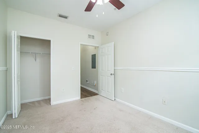 an empty room with chandelier fan