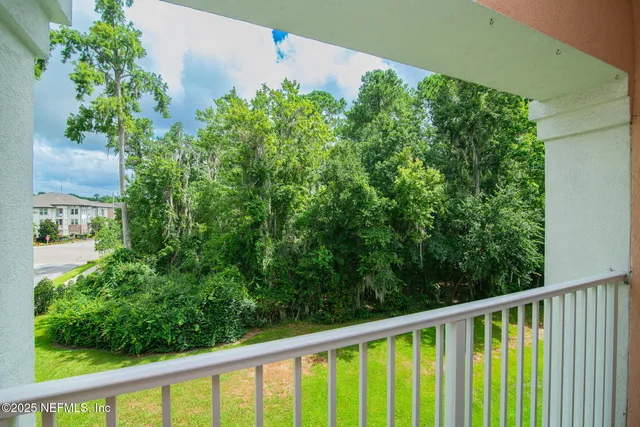 a view of a balcony with a yard