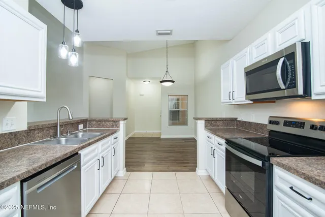 a kitchen with stainless steel appliances granite countertop a sink stove and microwave
