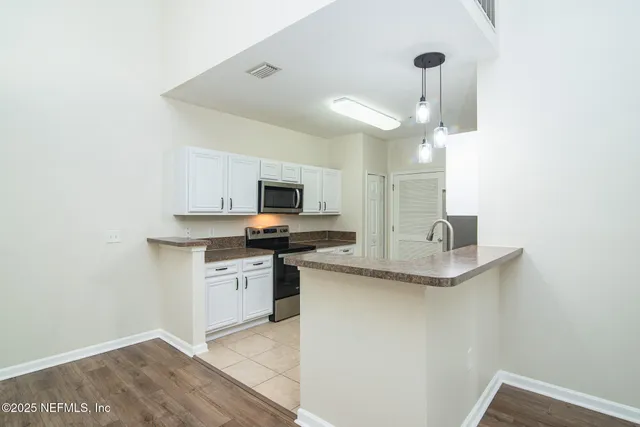 a kitchen with stainless steel appliances a sink a stove a microwave and cabinets