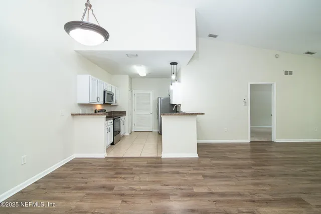 a view of a kitchen with sink and wooden floor