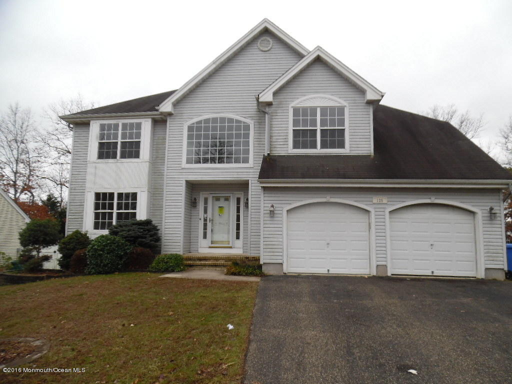 125 Swordfish Road Manahawkin, NJ 08050 - Photo 1 of 15 a front view of a house with a yard and garage