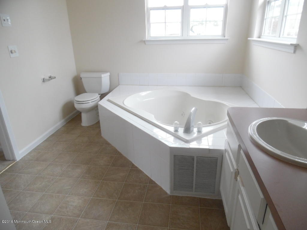 125 Swordfish Road Manahawkin, NJ 08050 - Photo 12 of 15 a bathroom with a sink a toilet and tub
