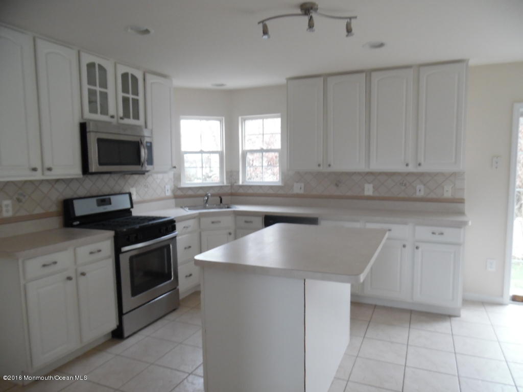 125 Swordfish Road Manahawkin, NJ 08050 - Photo 3 of 15 a kitchen with granite countertop a sink stove and microwave