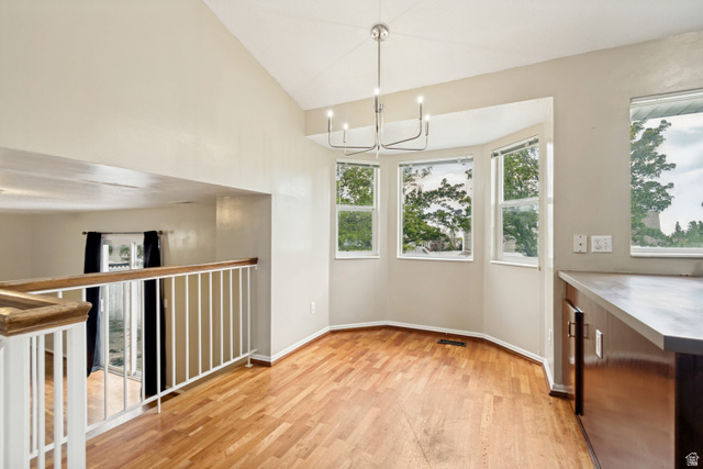 843 Deer Flat Road Tooele, UT 84074 - Photo 7 of 27 Dining area featuring wood-finish flooring, a modern chandelier, and a bay window with multiple panes