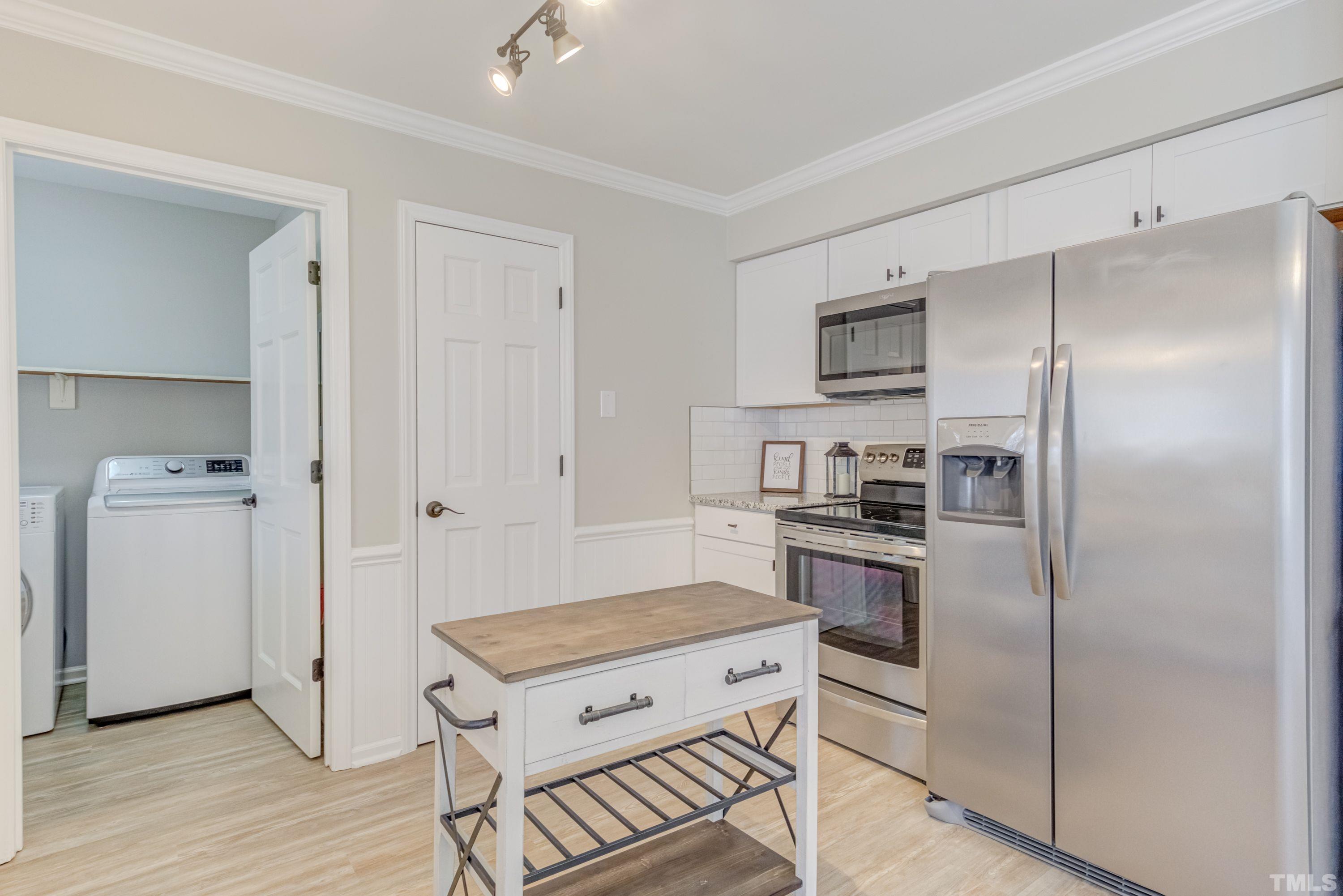 9305 Tallgrass Road Raleigh, NC 27603 - Photo 14 of 49 a kitchen with refrigerator cabinets and wooden floor
