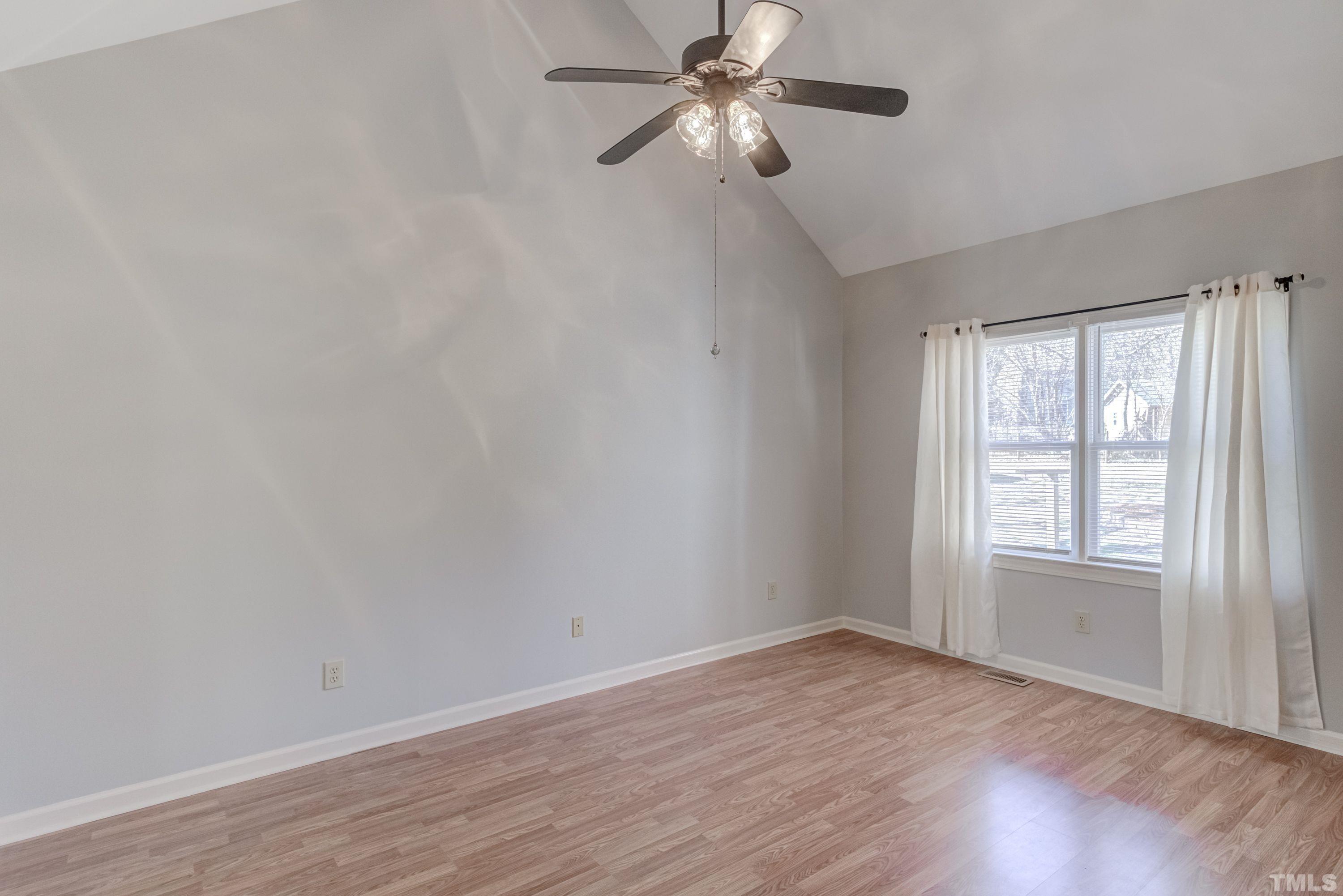 9305 Tallgrass Road Raleigh, NC 27603 - Photo 24 of 49 an empty room with wooden floor fan and windows