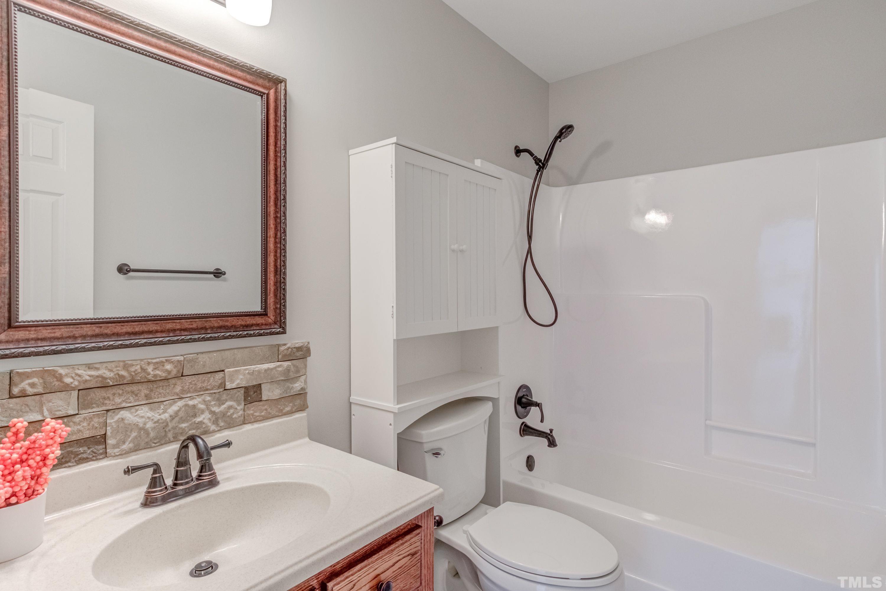 9305 Tallgrass Road Raleigh, NC 27603 - Photo 34 of 49 a bathroom with a sink toilet and shower