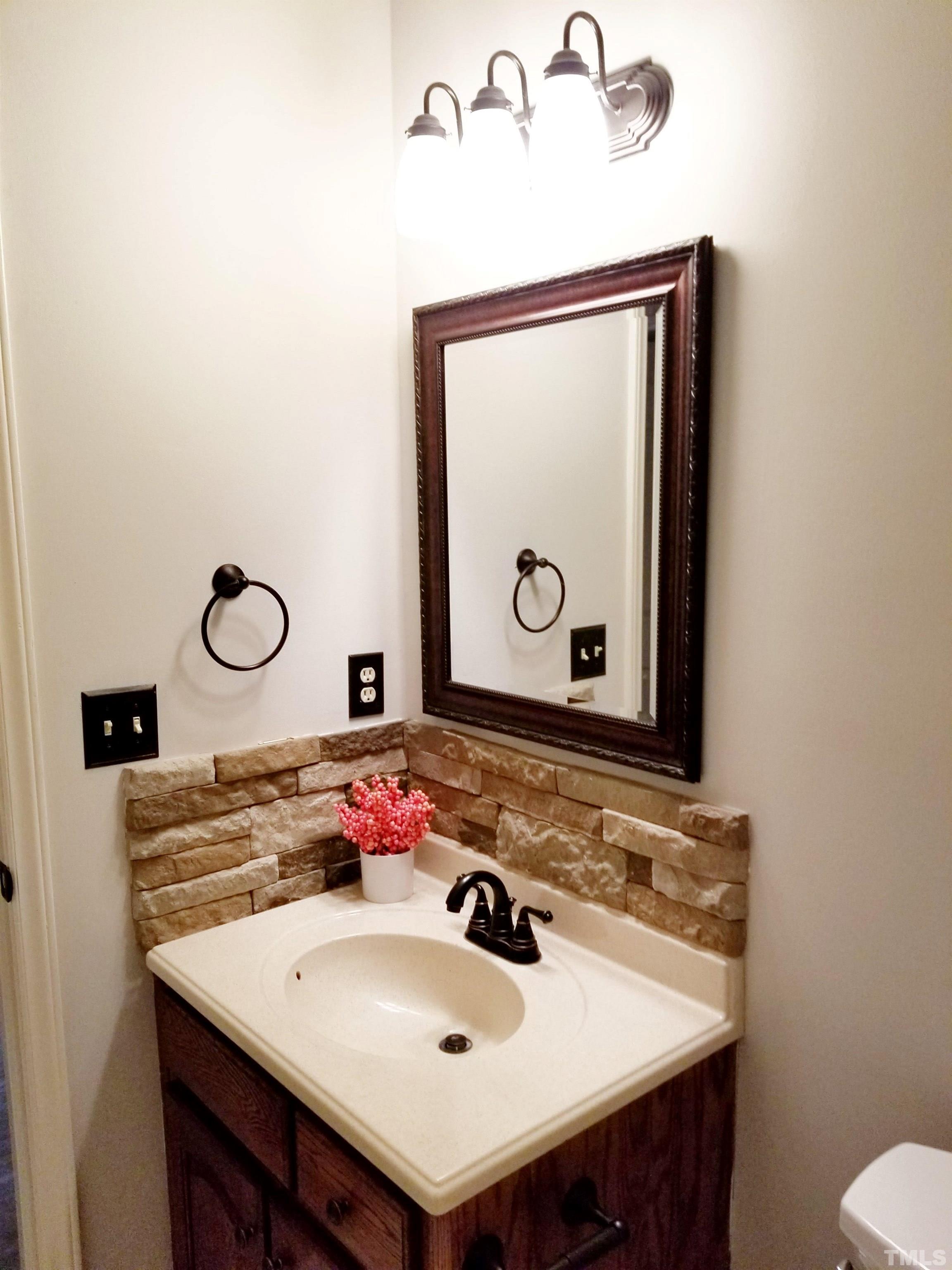 9305 Tallgrass Road Raleigh, NC 27603 - Photo 36 of 49 a bathroom with a sink and a mirror