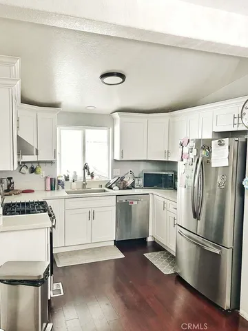 a kitchen with a refrigerator stove and white cabinets