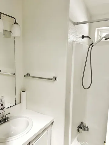 a bathroom with a sink a shower and a mirror