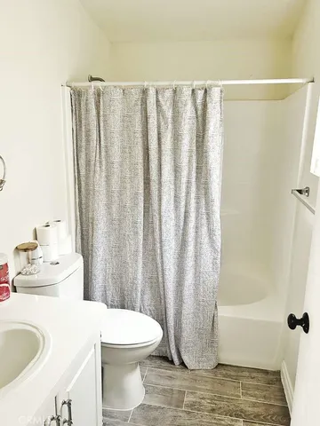 a bathroom with a sink a toilet and shower curtain