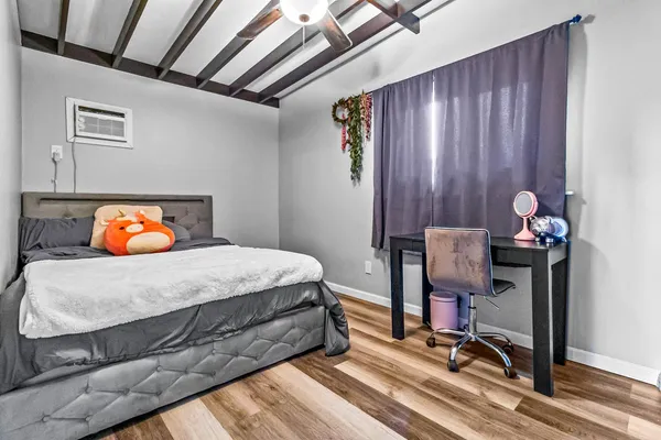 a bedroom with a bed and wooden floor