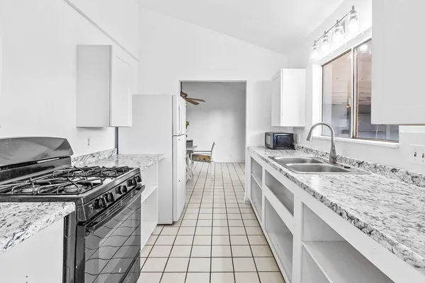 a kitchen with granite countertop a stove and a sink