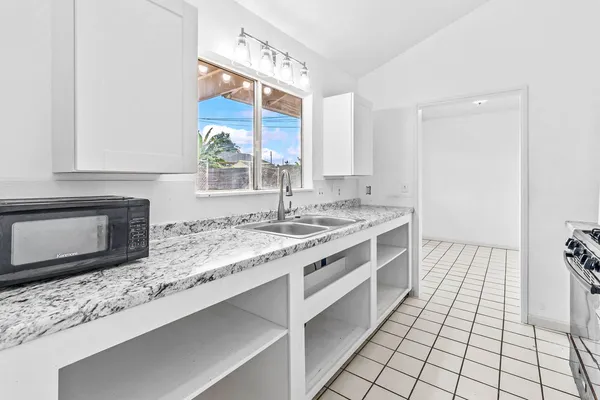 a kitchen with stainless steel appliances granite countertop a sink stove and cabinets