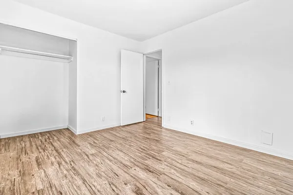 a view of an empty room with wooden floor