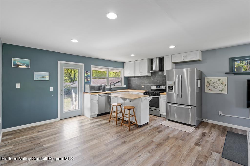 69 Mossybrook Road High Falls, NY 12440 - Photo 3 of 36 a kitchen with stainless steel appliances a refrigerator a sink dishwasher and a stove with wooden floor