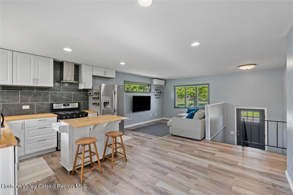 69 Mossybrook Road High Falls, NY 12440 - Photo 8 of 36 a kitchen with stainless steel appliances granite countertop a stove top oven a sink dishwasher and a refrigerator with wooden floor