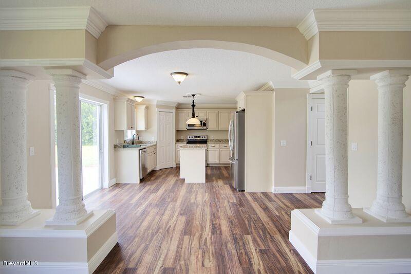 2139 Watkins Road Southeast Palm Bay, FL 32909 - Photo 32 of 32 a kitchen with a refrigerator and wooden floor