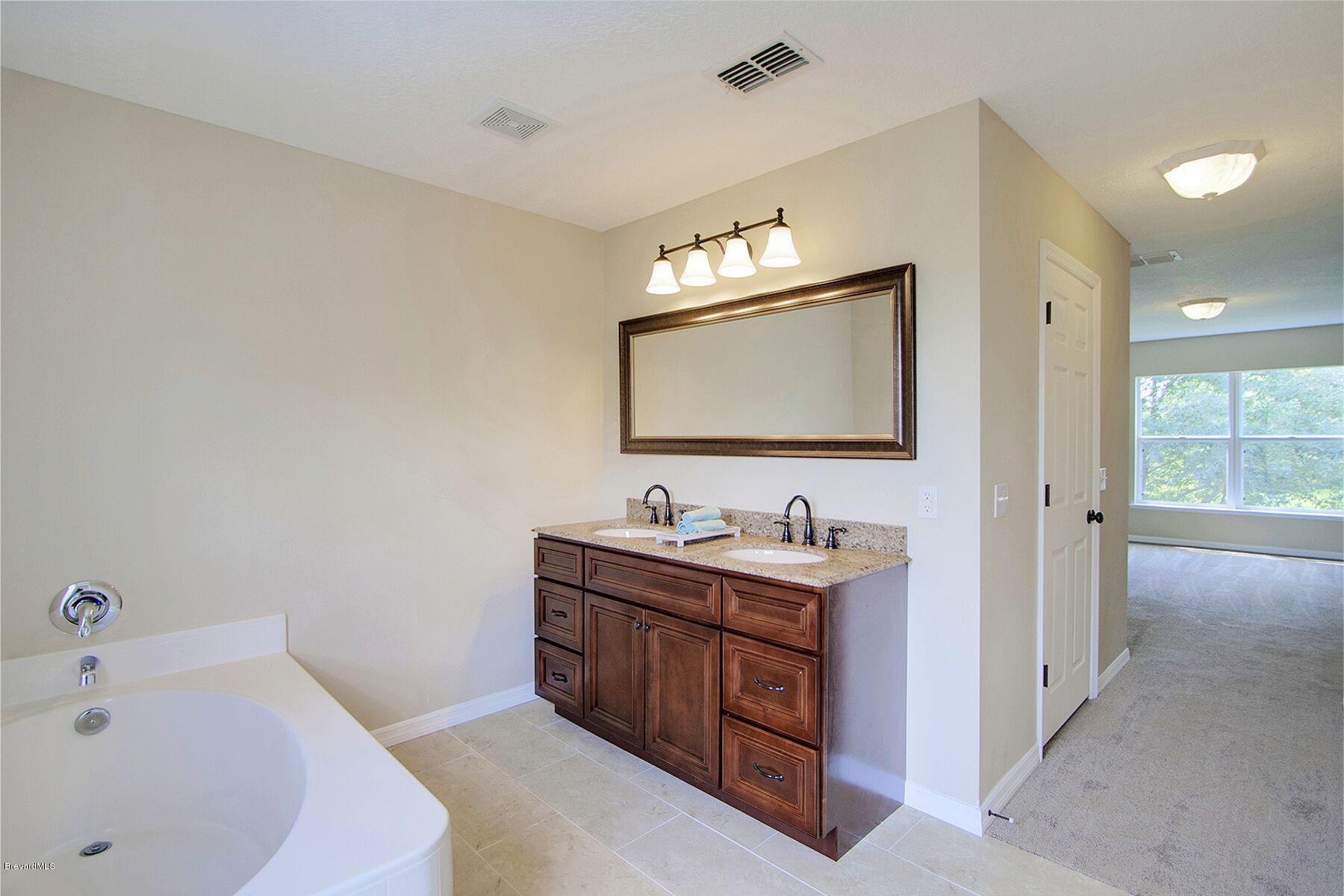 2139 Watkins Road Southeast Palm Bay, FL 32909 - Photo 17 of 32 a bathroom with a tub sink and mirror