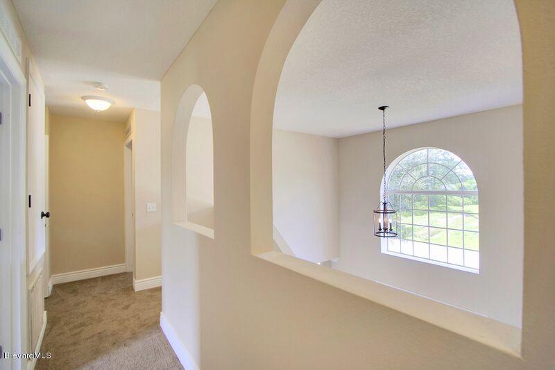 2139 Watkins Road Southeast Palm Bay, FL 32909 - Photo 25 of 32 an empty room with windows and chandelier