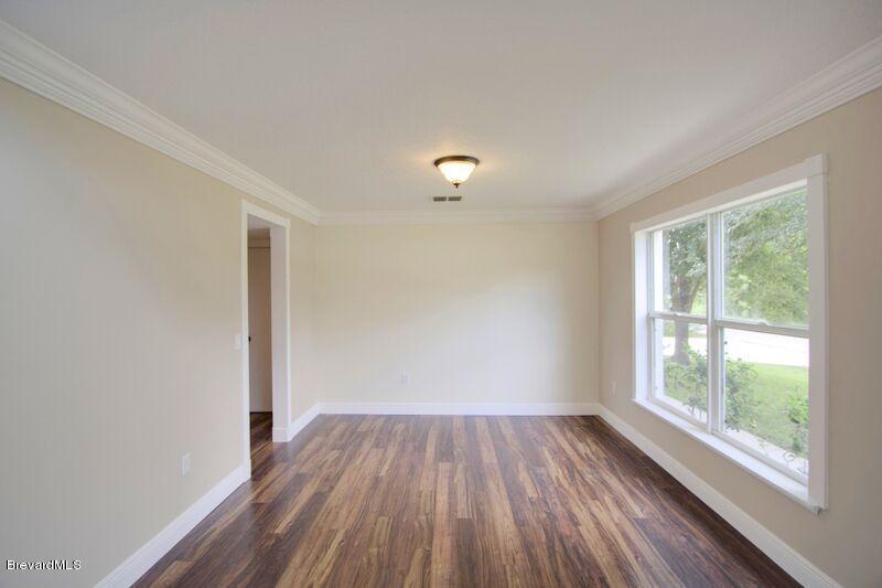 2139 Watkins Road Southeast Palm Bay, FL 32909 - Photo 4 of 32 a view of a room with wooden floor and windows