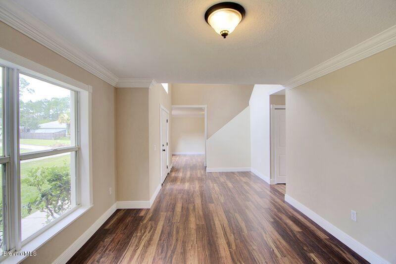 2139 Watkins Road Southeast Palm Bay, FL 32909 - Photo 5 of 32 a view of a room with wooden floor staircase and windows