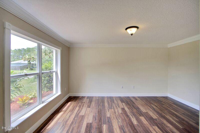 2139 Watkins Road Southeast Palm Bay, FL 32909 - Photo 6 of 32 a view of room with window and wooden floor