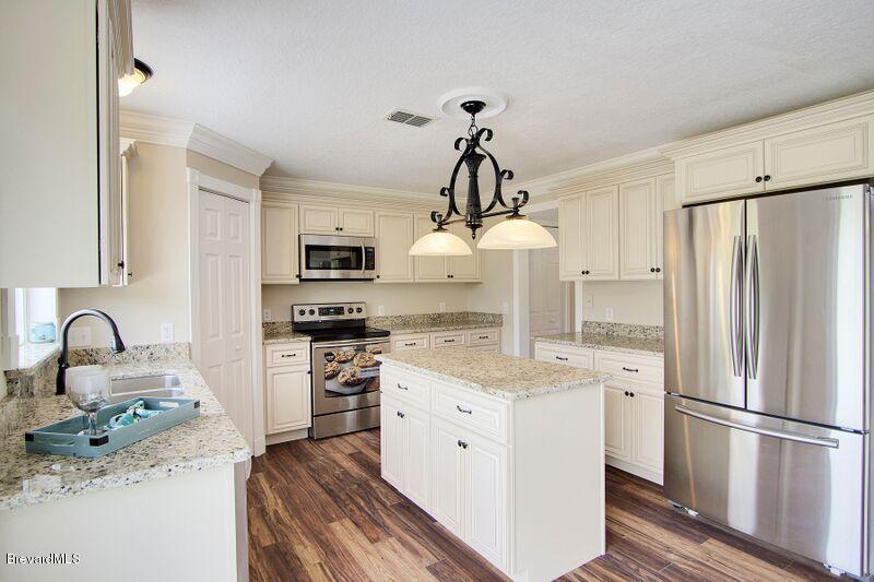 2139 Watkins Road Southeast Palm Bay, FL 32909 - Photo 9 of 32 a kitchen with granite countertop a refrigerator stove and sink