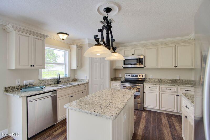 2139 Watkins Road Southeast Palm Bay, FL 32909 - Photo 10 of 32 a kitchen with stainless steel appliances granite countertop a sink stove and refrigerator