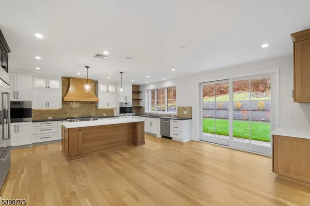 a kitchen with kitchen island a sink stainless steel appliances and wooden floor