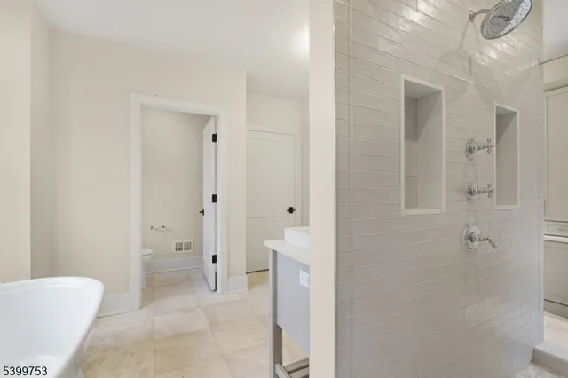 a bathroom with a sink double vanity granite tub and a mirror