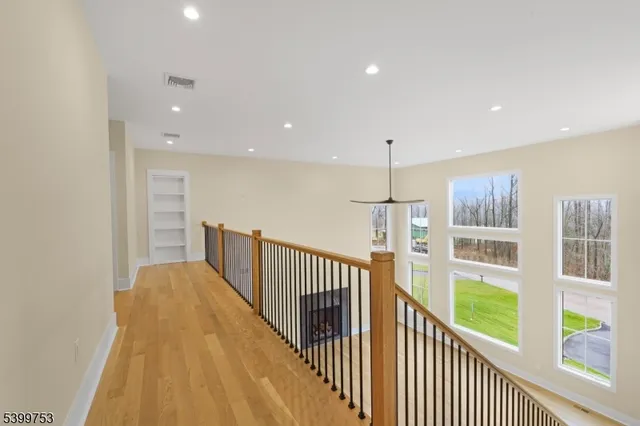 a view of a hallway with wooden floor and entryway
