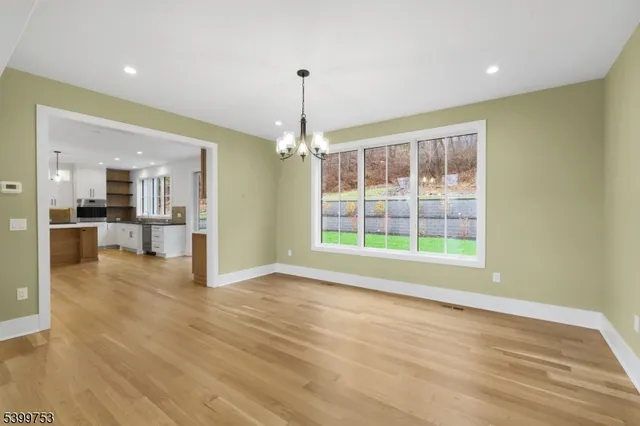 a large kitchen with kitchen island a large counter top stainless steel appliances and cabinets
