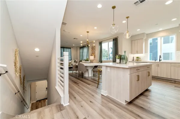 a kitchen with refrigerator a stove a sink and chairs