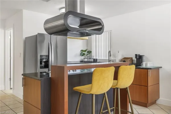 a kitchen with stainless steel appliances granite countertop a sink and a refrigerator
