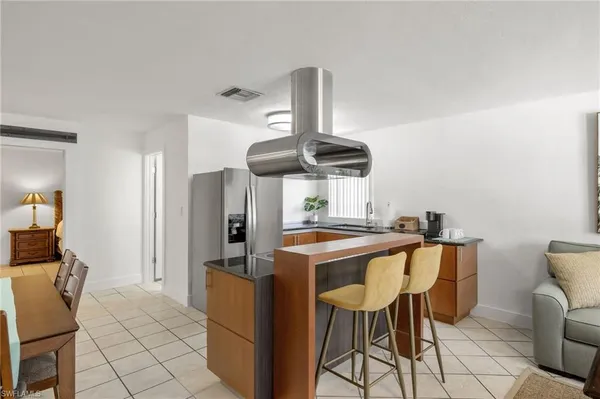 a kitchen with stainless steel appliances a table and chairs in it