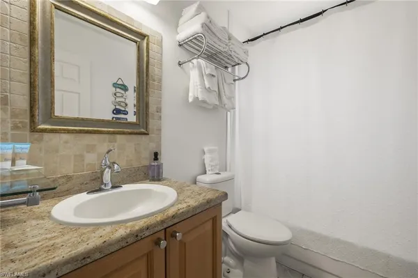 a bathroom with a sink vanity mirror and toilet