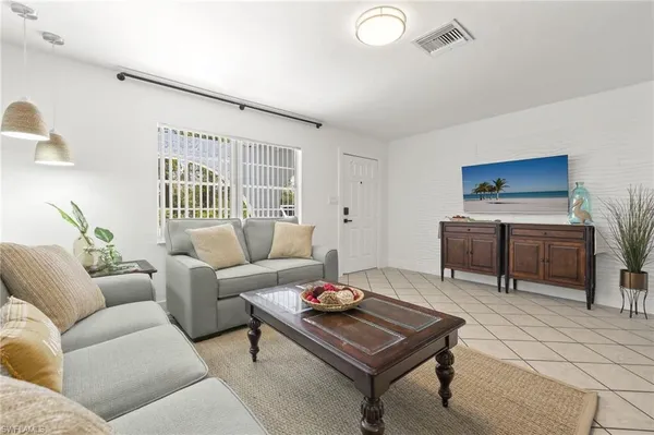 a living room with furniture a rug and a window