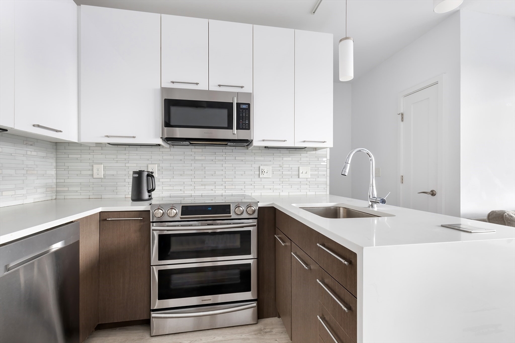 70 Bremen Street, Unit 501 Boston, MA 02128 - Photo 4 of 15 a kitchen with stainless steel appliances granite countertop a sink and a microwave
