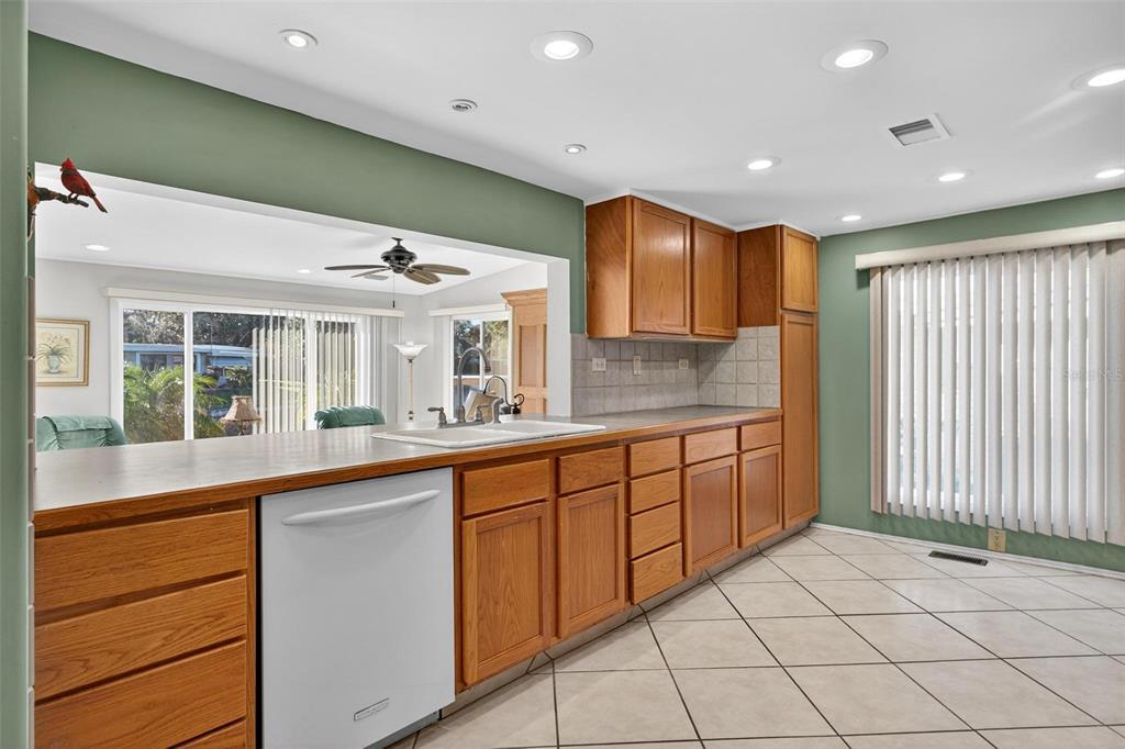 945 Todd Way Tavares, FL 32778 - Photo 24 of 75 a large kitchen with granite countertop a sink and dishwasher a stove with wooden cabinets