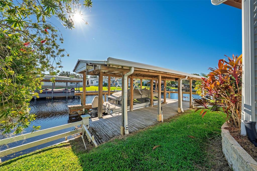 945 Todd Way Tavares, FL 32778 - Photo 52 of 75 a view of a patio with table and chairs potted plants with wooden floor and fence