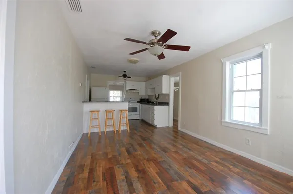 a view of a kitchen with wooden floor and a window